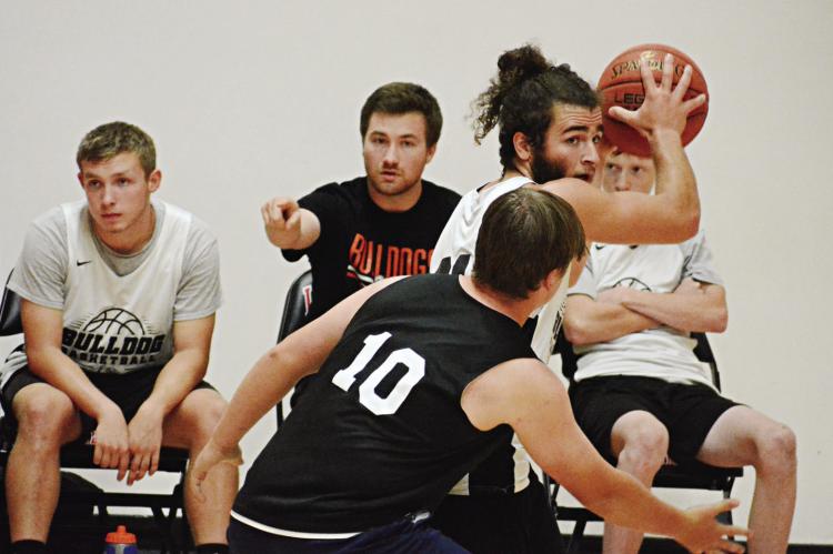WITH TEAMMATES and a pointing coach (August Hoeper) behind him, Denver Douglas shields the ball and looks to pass Monday at the Barker Center. SHAWN RONEY | Staff
