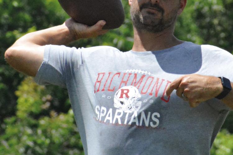 RICHMOND VARSITY COACH Nick Persell rears his arm back to throw as he leads his receivers and defensive backs through drills. SHAWN RONEY | Staff