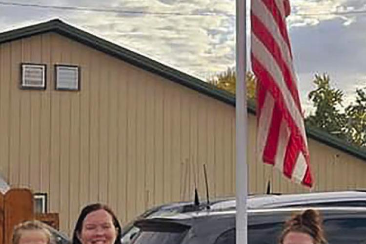 THE FAMILY OF FALLEN deputy Jeff Perkins is on hand to witness the flag being lowered to halfmast in his honor. Submitted