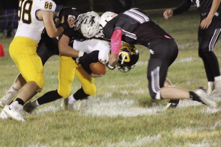 CALLED ON to fill the void left on offense by an injured Jaxon Miller, Orrick senior Zander Stevinson, No. 3, finds himself sandwiched between two Aggies while carrying the football Oct. 7 at Norborne. SOPHIA BALES | Staff