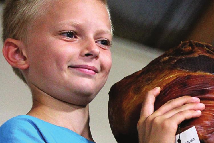 J.C. VENTIMIGLIA | Staff A LONG-TIME participant in Ray County Fair events, Cash Honeycutt, hoists his entry at the ham auction.