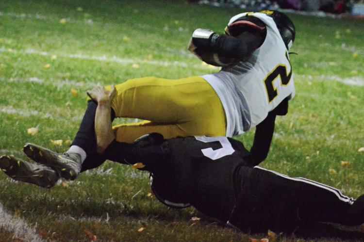 BRODY FIFER (bottom) lunges and brings down Orrick’s Gage Tebbe for a touchdown-saving tackle during the first quarter of Norborne Hardin-Central’s District 4 win over the Bearcats. SHAWN RONEY | Staff