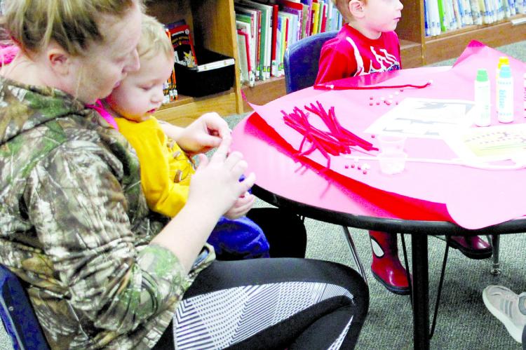 Haylee Young, Carson Campbell and Luke Ketterman make Christmas crafts during the Parents as Teachers event at Dear Elementary. The program helps children from prenatal to five years old to guide them before schooling.