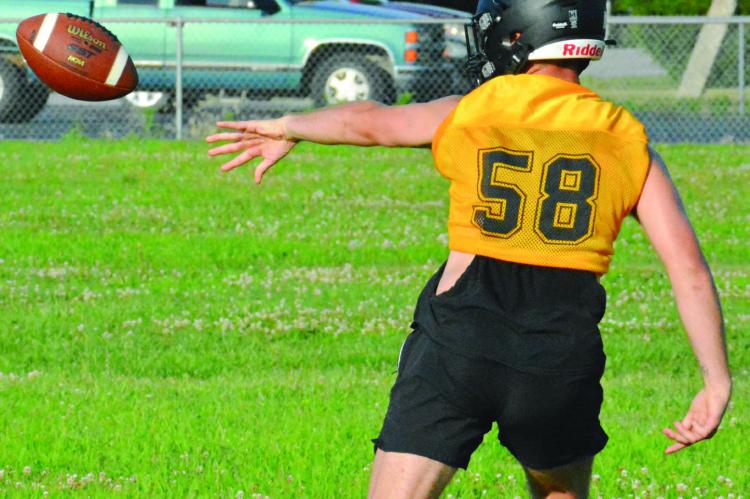 XAVIOR GASKINS pitches the ball back during one of his reps at quarterback on Orrick’s first day of varsity eight-man football team camp. SHAWN RONEY | Staff