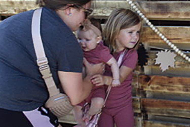 DARCY HUMDLEY (LEFT) places daughter Elie into Maylee’s arms for a photo-op.