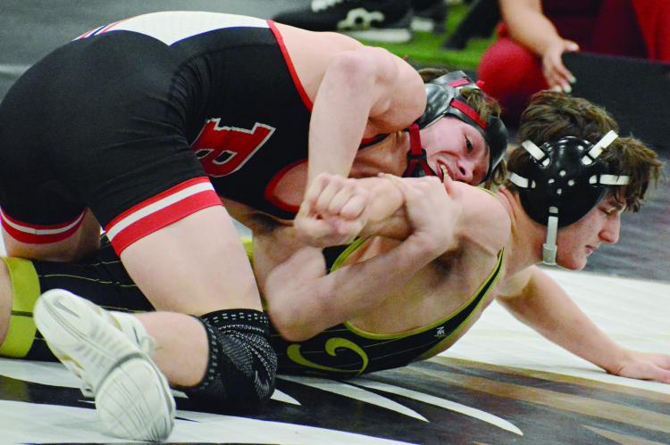 BRADY HYDER (left) works on the arm of Excelsior Springs’ Logan Bates during their title bout at Class 2 District 4 boys wrestling competition. SHAWN RONEY | Staff