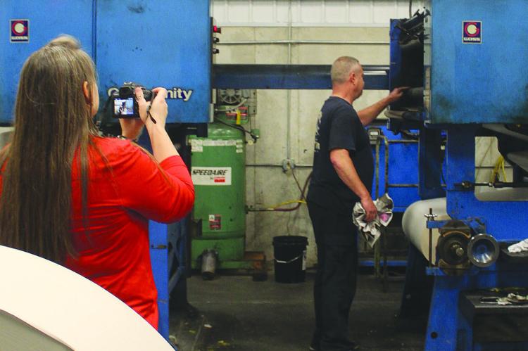 RICHMOND NEWS AND Excelsior Springs Standard Pressman Danny Shull checks ink distribution while journalism teacher Katherine Rold captures the process for her students. SHARON DONAT | Staff