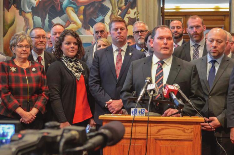 STATE REP. PEGGY McGAUGH, front row, far left, whose district includes all of Ray County, stands among fellow Republicans as House Speaker Rob Vescovo speaks during the Republican press conference in Jefferson City to open this year’s legislative session. BEN PETERS | Missouri House
