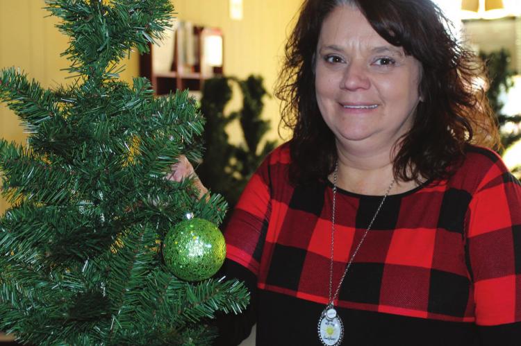 THE ANNUAL Christmas Tree Extravaganza will location has changed. Rather than being at the Richmond Area Chamber of Commerce Office, the event will open Friday at Shirkey Golf Course. Chamber Director Carolyn Arney places an ornament on the first of 35 trees that will be decorated. J.C. VENTIMIGLIA | Staff