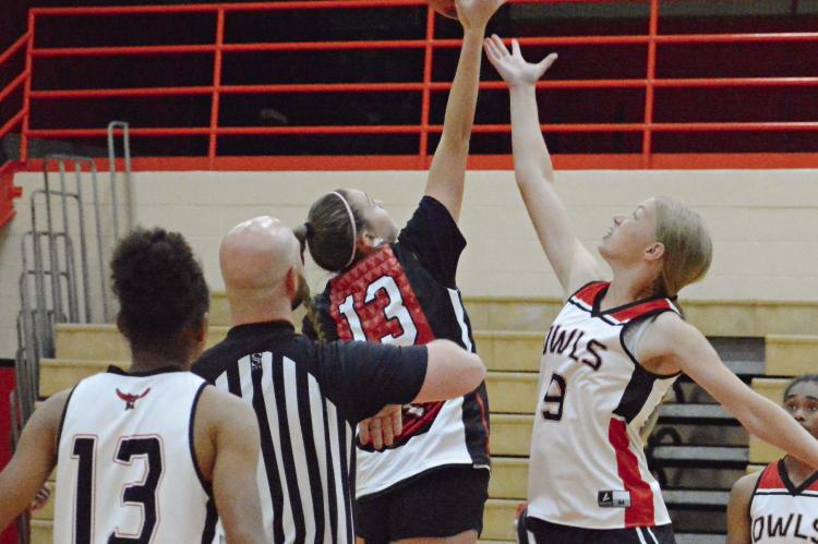 SEEMINGLY SURROUNDED by a parliament of Owls, Richmond’s Emma Hash (No. 13) leaps for the opening tipoff Monday against Marshall in summer-league play at Oak Grove. Hash and her Richmond teammates rebound from a loss to Marshall a few hours later by thumping Fort Osage, also at Oak Grove. SHAWN RONEY | Staff
