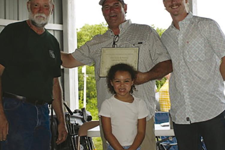 RAY COUNTY FAIR BOARD President Joel Richards (left) presents the 2025 Ray County Farm Family Award to Dale, Ashton and Kehlani Vandiver. Submitted