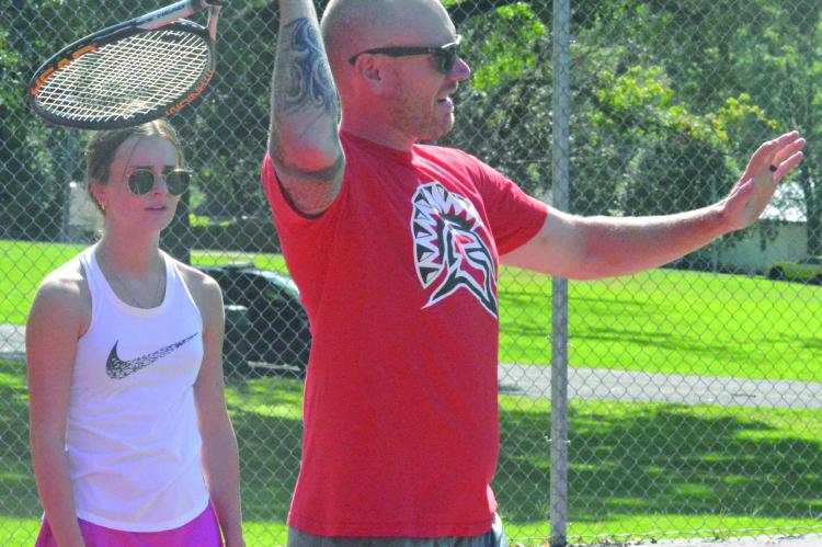 RACQUET IN HAND, new Richmond High School tennis coach Brent Behler discusses technique as Ava Scheible watches Aug. 15 at Maurice Roberts Park. SHAWN RONEY | Staff