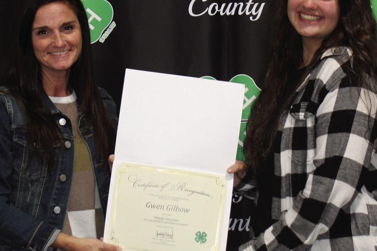 HEATHER AND PAIGE Logsdon show Frank Graham Volunteer certificate awarded posthumonusly for Gwen Gilbow’s service to 4-H.