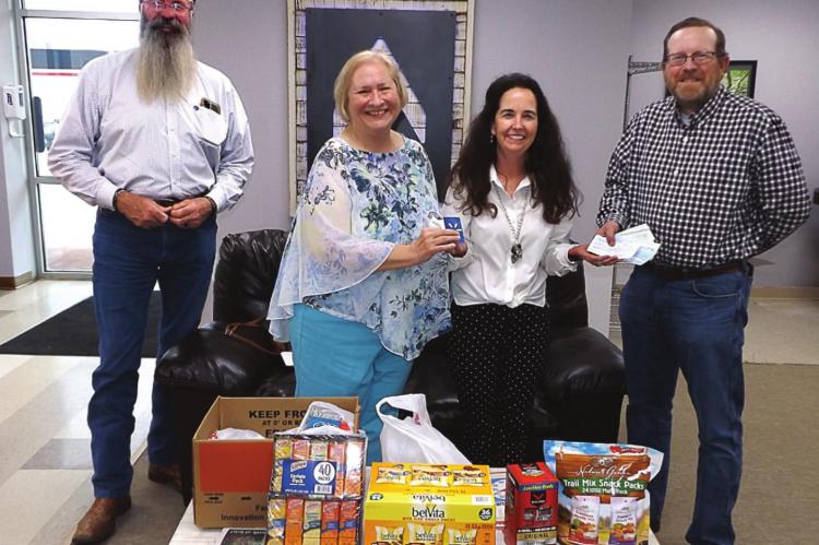 AT THE EXCHANGE of donation items and cash are, from left, Pastor Art Endsley, Barbara Britt, Michele Orpin of the Veterans Community Project and Tim O’Dell.