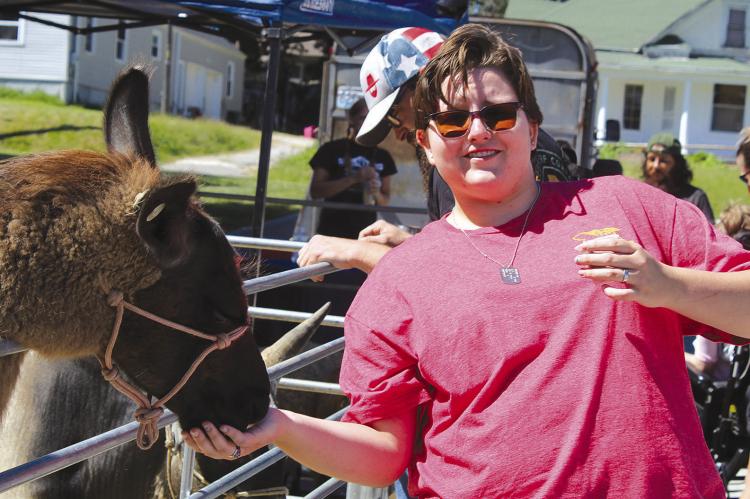KARCYN ROOT-GAINES feeds the llama at the petting zoo during the Community Emergency preparedness event.