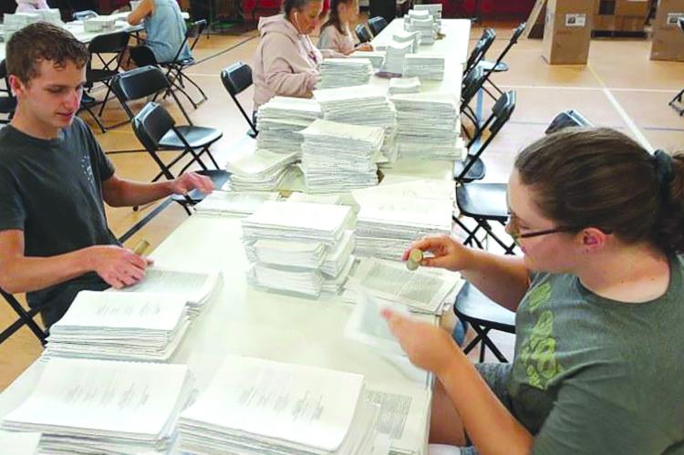 VOLUNTEERS ASSEMBLE Bibles at last year’s Bible Conference. ARCHIVE | Staff