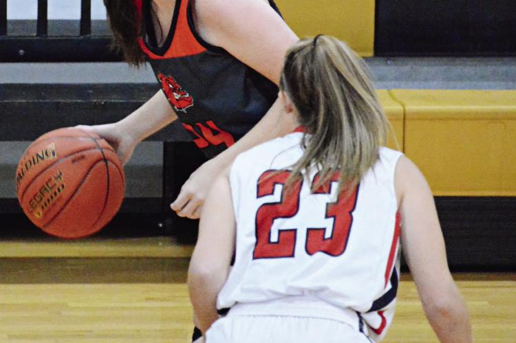 GUARDED BY senior Addyson Sweem, Hardin-Central junior Libby Fifer dribbles to her right during the Bulldogs’ 54-22 loss to Braymer Feb. 23 in Class 1 District 13 play at Norborne. SHAWN RONEY | Staff