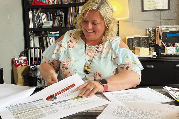 DR. MARLAINE BOYD, principal of Dear Elementary, looks through the blueprints of the upcoming Richmond Early Childhood Center. SOPHIA BALES | Staff