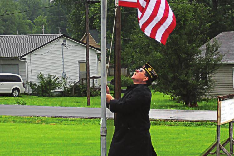 THE MEMORIAL DAY ceremony – a joint observance between Richmond’s American Legion and Veterans of Foreign Wars posts at Woodland Cemetery – starts in a soft rain with American Legion Commander Mark Foley raising the flag. Find more event photos on Page 10. J.C. VENTIMIGLIA | Staff