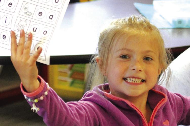 Alythia Miller holds up her worksheet during Dear Elementary summer school .