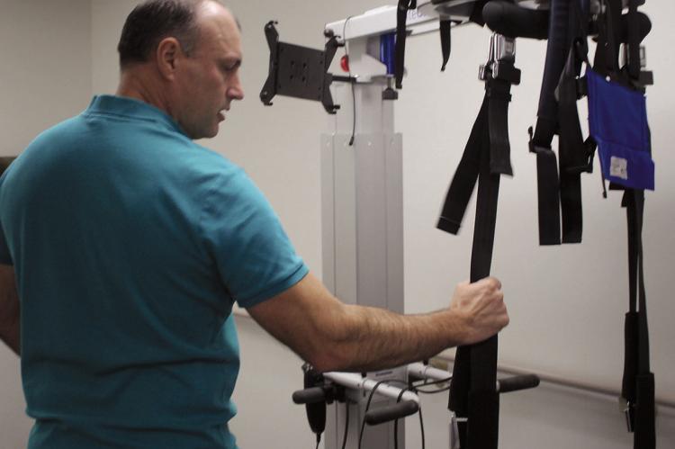 RANDY SINGLETON adjusts the Light Gate system used for lift support and gait training at Shirkey Premier Therapy.