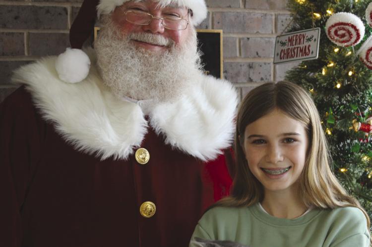 WHILE VISITING Ray County Humane Society, Santa wishes Lilo the kitten Christmas blessings at her new home with Kennedy Beal. SHARON DONAT | Staff