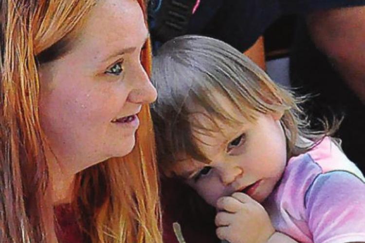 CAYENNE STARK holds her daughter, Gabriella, 2, at a drive-by party. SHAWN RONEY | Staff
