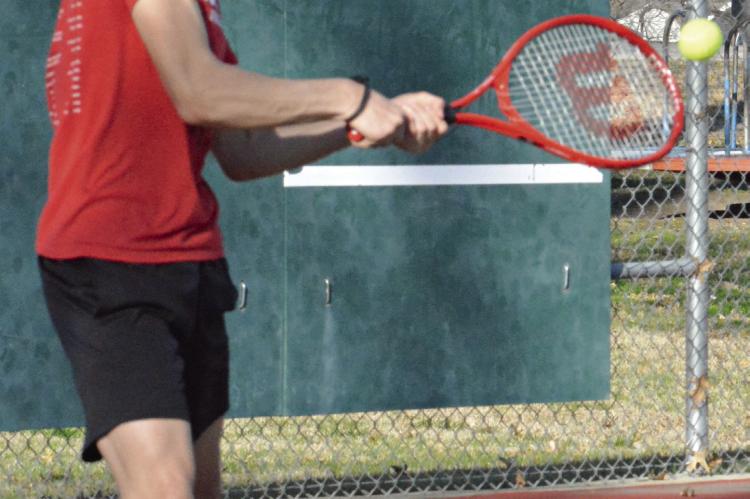 SHAWN RONEY | Staff JAXON AHART attempts a double-fisted backhand during a preseason practice. Ahart is the lone freshman on Richmond’s varsity boys tennis roster, Missouri State High School Activities Association information states.
