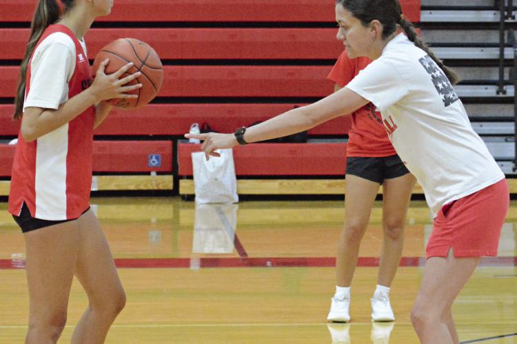 BRYLEE CASTILLEJA (left) and Richmond varsity girls basketball coach Kaylee Vantrump help demonstrate a drill during an offseason camp session. SHAWN RONEY | Staff