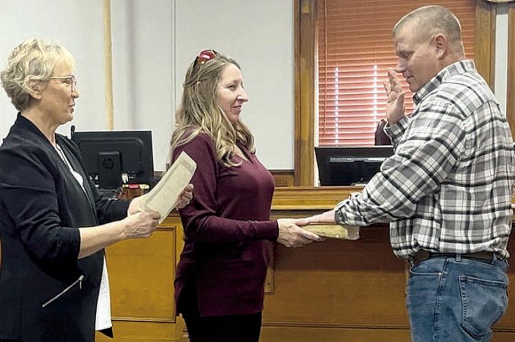 RETIRED RAY COUNTY CLERK Glenda Powell (left), administers the oath of office for Presiding Commissioner Billy Gaines (right), as his wife, Kathie, holds the bible. SOPHIA BALES | Staff