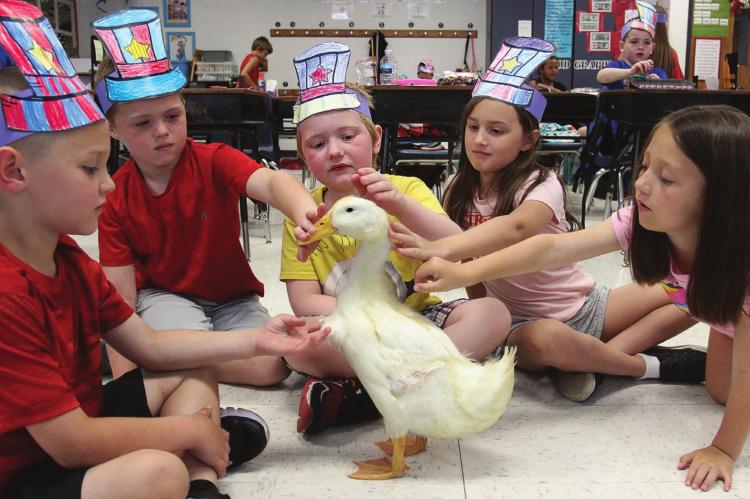 A GROUP of 7-year-olds interacts with Mighty Sparky Duckerton in Kerra Bowers’ classroom at Sunrise Elementary School. From left are Breyden Erickson, Jaxx Hicks, Zarek WightHayden, Amarie Hyder and Presley Minnick. J.C. VENTIMIGLIA | Staff