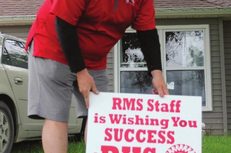 KENT WOLLARD plants a sign.