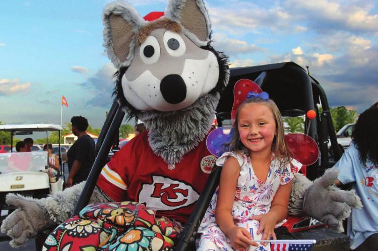 THE RICHMOND American Celebration Children's Parade grand marshal Kansas City Chiefs mascot KC Wolf, hitches a ride with Oaklee Cloninger, 6.