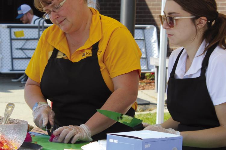 REGIONAL FOOD SYSTEM managers Deb O’Neal (left) and Ellen Bloomer-Thornton demonstrate an easy summer recipe using items available from local farmer’s markets.