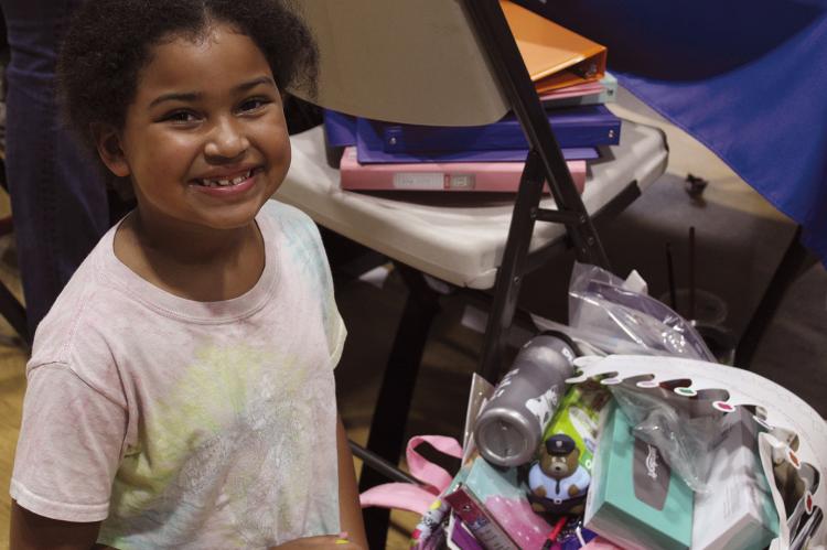 MAISIE ELLIE shows off her new backpack and school supplies.