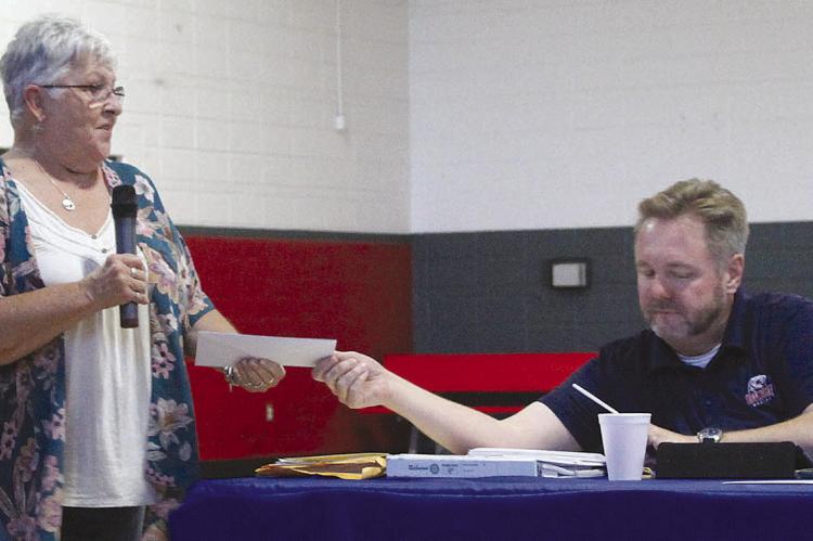 NANCY COLEMAN (left) receives a Rotary grant for the Ray County Fair Board from Rob Swafford. SHARON DONAT | Staff