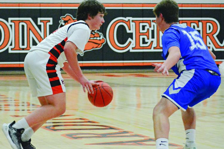 SOPHOMORE COLLIN LYON (left) looks to drive for Hardin-Central in the fourth quarter while guarded by Tri-County junior Carter Fewins. SHAWN RONEY | Staff