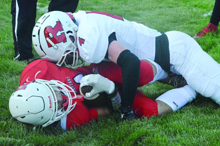 SOPHOMORE DRYDEN HENDRIX keeps the football firmly tucked into his right side after being driven out of bounds by Nolan Quick Monday during the Red and White Scrimmage Monday at Spartan Stadium. SHAWN RONEY | Staff