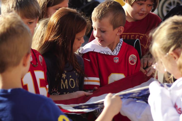 SOPHIA BALES | Staff FOURTH-GRADERS Fynleigh Orr and Jahred Case help others fold the American Flag Sept. 9 at Sunrise Elementary in Richmond as the students learn about flag etiquette from VFW members.