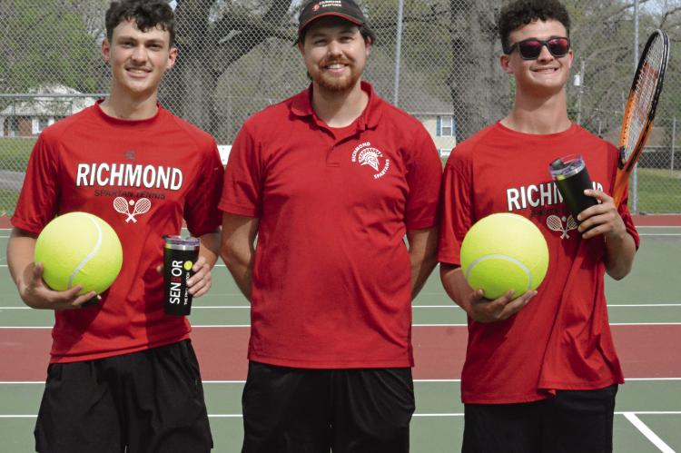 SENIORS BRODY BURNINE (left) and Jazspher Ulleberg (right) display the oversized tennis balls and tumbler cups presented to them on Senior Night as they flank Richmond tennis coach Zachary Baldauf. Tennis coverage continues on page 12. SHAWN RONEY | Staff