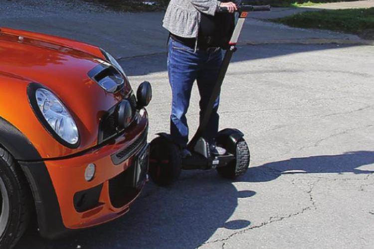 ON A SEGWAY, Hilary Morrissey, Macon, helps direct some of the estimated three dozen participants in the Mini Cooper Rally to parking spots on West Main Street.