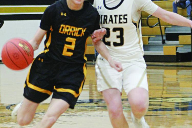 ORRICK SENIOR Logan Smith (left) dribbles during the Bearcats’ Class 1 District 13 Tournament opener with tournament host Norborne. The Bearcats sink the Pirates 82-26 to advance to the semis of the postseason single-elimination tournament. The Bearcats were scheduled to face Braymer Wednesday, with the Orrick and Hardin-Central girls set to open districts Tuesday.