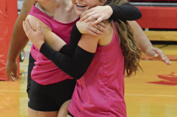 SYDNEE BURNETT (left) and Genevieve Didier embrace after a set victory, with AJ Jones behind them. SHAWN RONEY | Staff