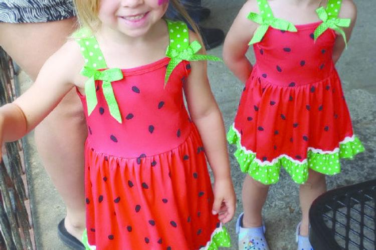OLIVIA AND CHLOE DEHN, with faces painted, step up to get hot dogs for lunch at Victory in the Park.