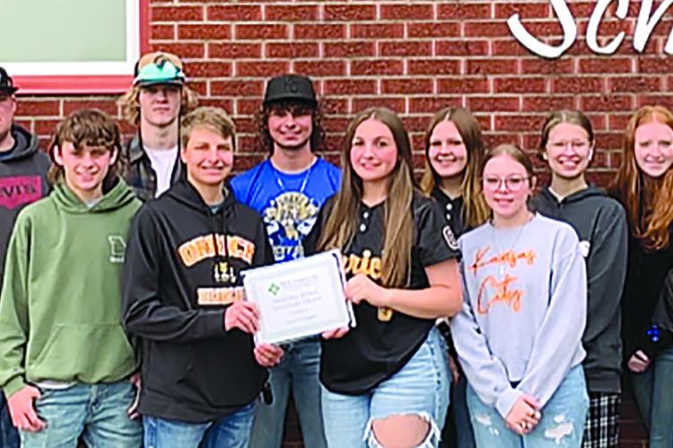 HIGGINSVILLE AREA FCS Financial Vice President Andrew Homfeld (left), awards grant to OHS FFA students Jacob McElwee, Elye McElwee, Maddox Peterson, Luke Smith, Gunner Smith, Cash Honeycutt, Hunter Spear, Isabel Wheeler, Natasha Hicks, Elana Boude, Aerin Cook, Natalie Williams, Hailey Haun, Shelbie McElwee and Dallas Lynn with Higginsville area FCS Financial Assistant Vice President Mike Mason. The team plans to upkeep the Ray County Fairgrounds. Submitted