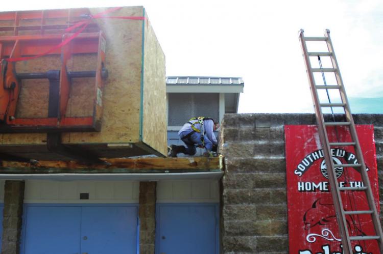 UP ON THE ROOF at the Richmond pool, CentiMark Corp. employee Christopher Jordan engages in repairs. J.C. VENTIMIGLIA | Staff