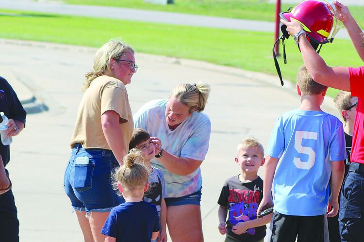 CHILDREN ATTENDEES try on the Richmond Fire Department helmets. SHARON DONAT | Staff