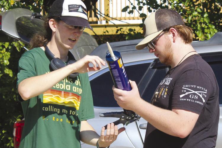 LARAMIE SULLARD (left) reviews plans and materials with a volunteer before starting construction on his Eagle Scout project for the Humane Society of Ray County’s new facility in the former Baldwin Electric building. SHARON DONAT | Staff