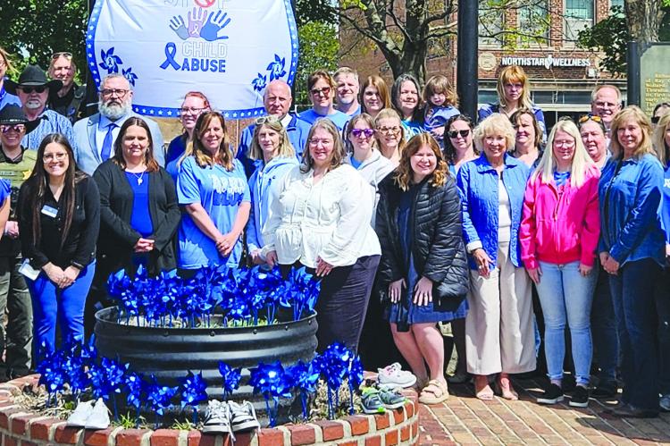 COMMUNITY MEMBERS, local officials and child advocacy partners raise awareness for Child Abuse Awareness Month during a courthouse event focused on protecting children in Ray County. MIRANDA JAMISON | Staff