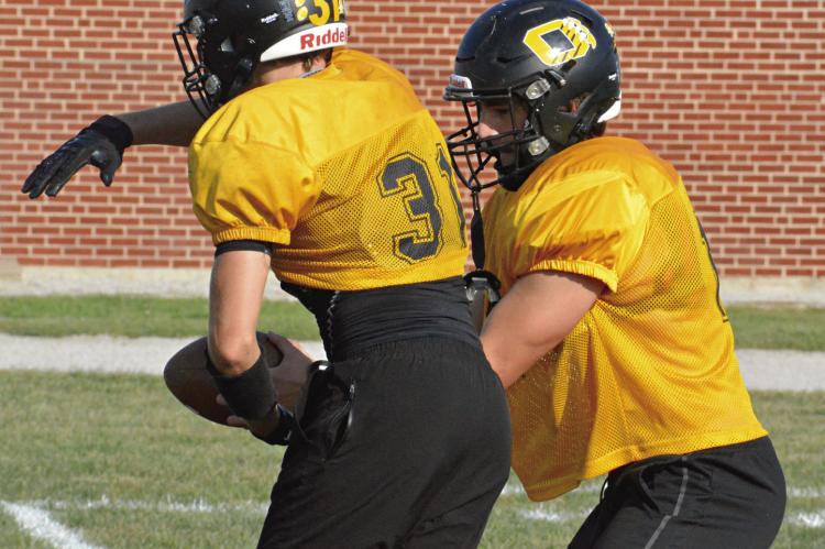JEFF ROHDE (No. 31) fakes a handoff from Orrick senior quarterback Jaxon Miller Monday afternoon at Simmons Field as the Bearcats prep for Friday’s home meeting with Missouri Highway 10 rival Norborne Hardin-Central. SHAWN RONEY | Staff